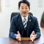 クライアントに説明する男性弁護士。離婚と子どもとの断絶に直面した親が弁護士に相談する。